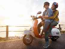 Gothaer Leichtkraftrad-Versicherung: Paar auf Leichtkraftrad freut sich über seine gute Versicherung.